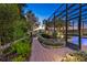 Manicured backyard featuring lush landscaping, a brick walkway, and a screened-in pool at 3358 Fernlake Pl, Longwood, FL 32779