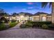 Elegant home with brick driveway, manicured landscaping, and inviting entrance at dusk at 3358 Fernlake Pl, Longwood, FL 32779
