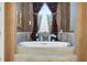 Luxurious soaking tub with decorative window and elegant candles in the bathroom at 3358 Fernlake Pl, Longwood, FL 32779