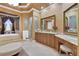 Elegant main bathroom with a soaking tub, walk-in shower, granite counters, and vanity with makeup area at 3358 Fernlake Pl, Longwood, FL 32779