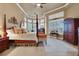 Spacious main bedroom featuring a four-poster bed, bay windows, sitting area, and ample natural light at 3358 Fernlake Pl, Longwood, FL 32779