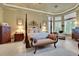 Tranquil main bedroom features a four-poster bed, bay windows, and a cozy sitting area for relaxation at 3358 Fernlake Pl, Longwood, FL 32779