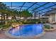 Stunning pool with waterfall feature and lush tropical landscaping in a screened enclosure at 3358 Fernlake Pl, Longwood, FL 32779