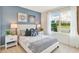 Cozy bedroom with a large window, soft lighting, and a blue accent wall at 33605 Seattle Slew Dr, Sorrento, FL 32776