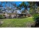 A spacious backyard with a large lawn and patio, bordered by mature trees at 3407 Pershing Ave, Orlando, FL 32812