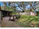 Spacious backyard with brick patio, screen porch, gardening station, and wooden fence at 3407 Pershing Ave, Orlando, FL 32812