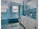 Bathroom with dual sinks, vintage blue tile, tub and a colorful tile floor at 3407 Pershing Ave, Orlando, FL 32812