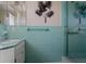 Retro bathroom showcasing unique teal tile, vanity, and a glass-enclosed shower at 3407 Pershing Ave, Orlando, FL 32812