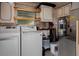 A laundry room featuring a washer, a dryer, and storage shelves at 3407 Pershing Ave, Orlando, FL 32812
