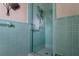 Stylish teal-tiled shower showcasing retro design and glass door at 3407 Pershing Ave, Orlando, FL 32812