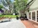 Relaxing backyard patio with wicker furniture, lush greenery, and shade, perfect for outdoor gatherings and relaxation at 5646 Spring Run Ave, Orlando, FL 32819