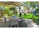 Inviting backyard with a round table, outdoor chairs, and a lush lawn, perfect for outdoor dining and entertaining at 5646 Spring Run Ave, Orlando, FL 32819