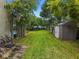 Spacious backyard featuring a large grassy area, lush greenery, a storage shed, and recreational equipment at 5646 Spring Run Ave, Orlando, FL 32819