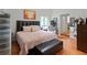 Comfortable bedroom with a pink-patterned comforter, brown leather bench, and brick tile floors at 5646 Spring Run Ave, Orlando, FL 32819