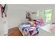 Bright bedroom with hardwood floors, a twin bed, and a window with natural light, providing a cozy and cheerful space at 5646 Spring Run Ave, Orlando, FL 32819