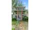 Charming cottage with a welcoming porch, a white door, tiki torches, and well-maintained greenery, creating a cozy retreat at 5646 Spring Run Ave, Orlando, FL 32819