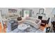 Open-concept living room with multiple seating areas, a fireplace, and large windows providing ample natural light at 5646 Spring Run Ave, Orlando, FL 32819