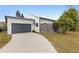 Modern home featuring a gray garage door, minimalist landscaping, and a driveway with contemporary appeal at 5706 Satel Dr, Orlando, FL 32810