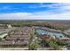 Wide aerial view of community condos, lake, amenities, and surrounding nature at 5766 Lesabre Dr, Kissimmee, FL 34746