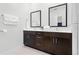Bathroom showcasing dual sinks with dark cabinets, white counters and tile floors, and a shower stall at 5766 Lesabre Dr, Kissimmee, FL 34746