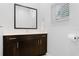 Bathroom featuring dark wood vanity with white quartz countertops and a large mirror at 5766 Lesabre Dr, Kissimmee, FL 34746