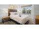Bright bedroom featuring a plush bed, stylish lamps, and a large window at 5766 Lesabre Dr, Kissimmee, FL 34746