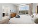 Bright bedroom featuring neutral walls, large window, king bed, and ensuite bathroom with glass shower at 5766 Lesabre Dr, Kissimmee, FL 34746