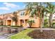 Attractive townhome featuring a tile roof, colorful exterior, and mature trees enhancing its curb appeal at 5766 Lesabre Dr, Kissimmee, FL 34746