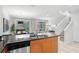 Open-concept kitchen featuring stainless steel appliances, a breakfast bar, and access to the living area at 5766 Lesabre Dr, Kissimmee, FL 34746