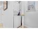 Laundry room with stacked washer and dryer, white walls and a window with blinds at 5766 Lesabre Dr, Kissimmee, FL 34746