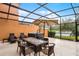 Screened-in patio featuring hot tub, seating, umbrella, and tranquil outdoor space at 5766 Lesabre Dr, Kissimmee, FL 34746