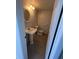 Compact half bathroom features pedestal sink and neutral tile floors at 6046 Village Cir # 6046, Orlando, FL 32822