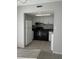 Kitchen featuring tile backsplash, black appliances, and white cabinetry at 6046 Village Cir # 6046, Orlando, FL 32822
