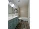 Well-lit bathroom with tiled shower and vanity with a blue cabinet at 620 Georgetown Dr # 620, Casselberry, FL 32707