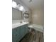 Well-lit bathroom with tiled shower and vanity with a blue cabinet at 620 Georgetown Dr # 620, Casselberry, FL 32707