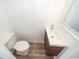 Powder room featuring a white toilet, sink, dark wood cabinet, mirror, and tile flooring at 620 Georgetown Dr # 620, Casselberry, FL 32707