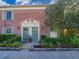 Charming brick townhome featuring twin entrances with green doors, lush landscaping, and a mature shade tree at 620 Georgetown Dr # 620, Casselberry, FL 32707