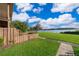 A fenced in back yard overlooking the lake with green grass and a walking path at 620 Georgetown Dr # 620, Casselberry, FL 32707