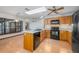 Kitchen featuring an island, granite counters, wood cabinets, and open floor plan to the living room at 685 Vistawilla Dr, Winter Springs, FL 32708