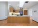 Kitchen featuring an island, granite counters, wood cabinets, stainless steel appliances, and a skylight at 685 Vistawilla Dr, Winter Springs, FL 32708
