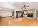 Open-concept living room featuring wood floors, a stone fireplace, access to the pool, and plenty of natural light at 685 Vistawilla Dr, Winter Springs, FL 32708