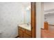 Traditional powder room featuring floral wallpaper, vanity with a sink, and wood cabinetry at 685 Vistawilla Dr, Winter Springs, FL 32708