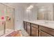 Bathroom features double sinks, tile floors, and a shower with glass door at 7517 Laureate Blvd # 4206, Orlando, FL 32827