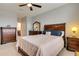 This bedroom offers a neutral carpet, ceiling fan, and wood furniture at 7517 Laureate Blvd # 4206, Orlando, FL 32827