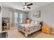 This carpeted bedroom features two large windows and light wood furniture at 7517 Laureate Blvd # 4206, Orlando, FL 32827