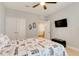 Carpeted bedroom with ceiling fan, trunk, and wall-mounted TV at 7517 Laureate Blvd # 4206, Orlando, FL 32827