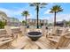 Relaxing fire pit area with outdoor seating and palm trees in a resort-style community at 7517 Laureate Blvd # 4206, Orlando, FL 32827