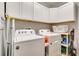 Bright laundry room with washer, dryer, and overhead storage cabinets at 7517 Laureate Blvd # 4206, Orlando, FL 32827