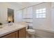 Bathroom featuring a single sink vanity, framed mirror, tiled tub and shower, and commode at 7902 Silver Bass Ct, Kissimmee, FL 34747
