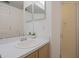 Bathroom with a single sink vanity, a large mirror, and glass shower door at 7902 Silver Bass Ct, Kissimmee, FL 34747